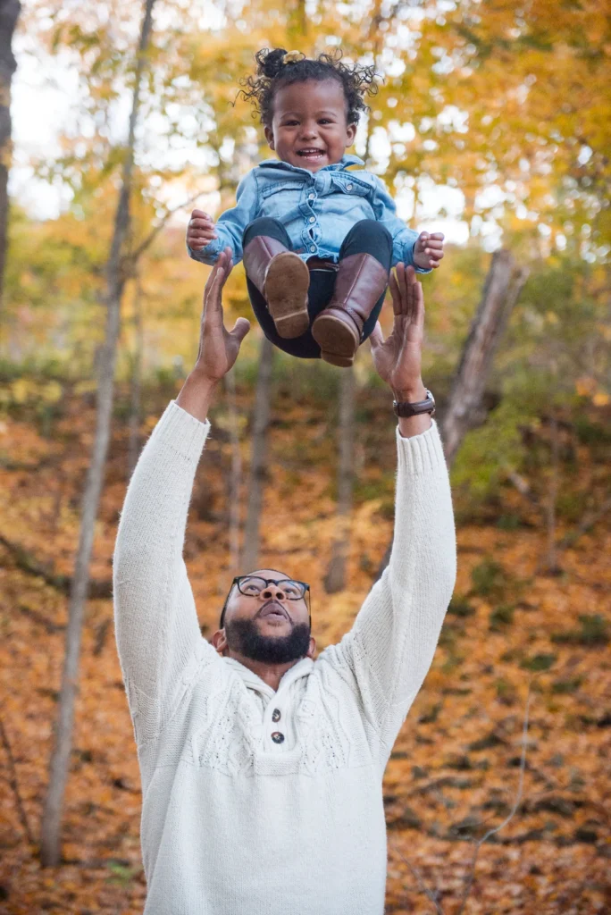 a father throw his little daughter in the air - a family portrait shot at the Rail Trail in Hamilton, Ontario