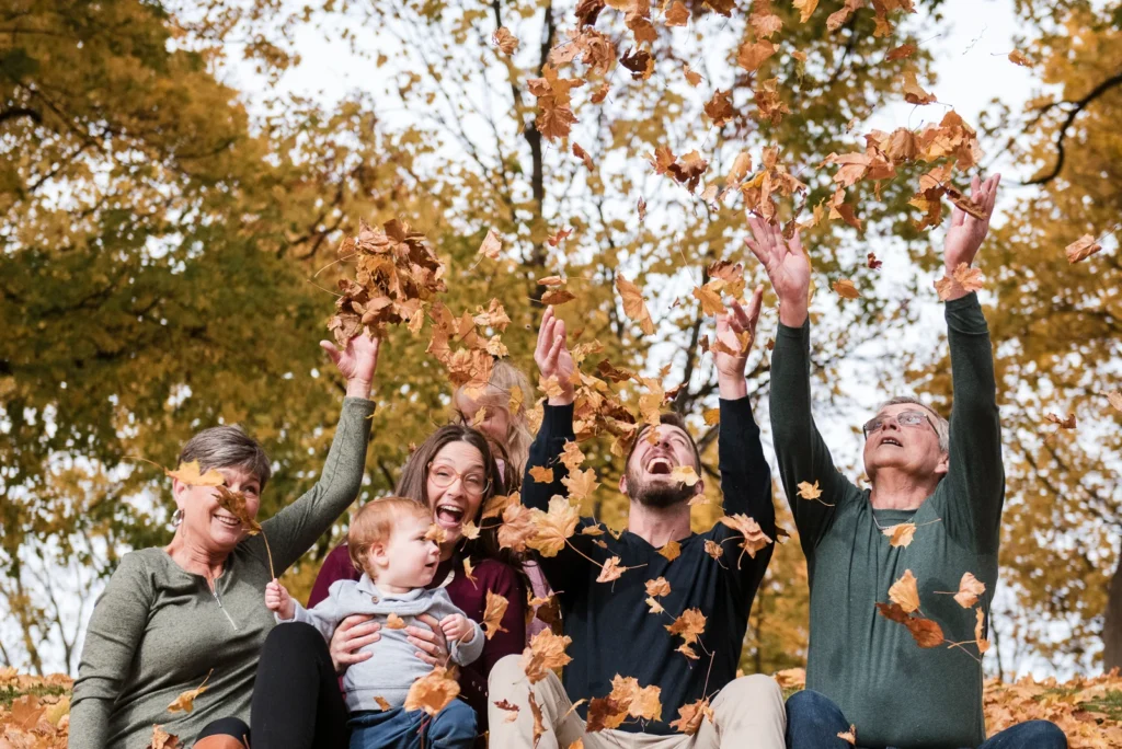 a family portrait of a family playing in autumn leaves -shot at dundurn castle in hamilton ontario