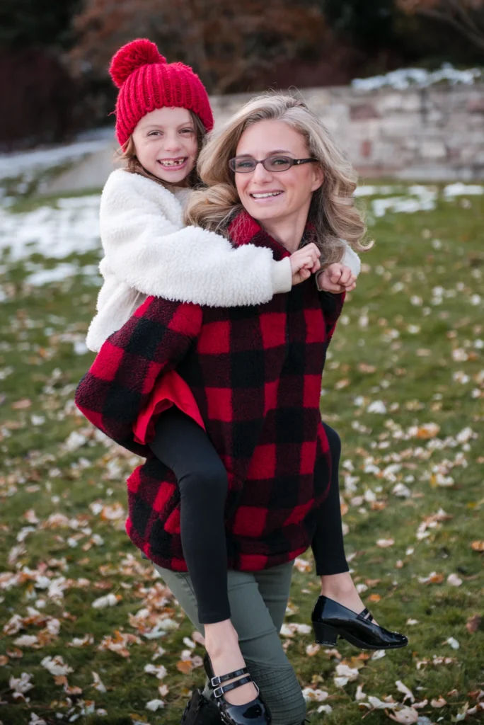 a mother carries her daughter on her back - a family portrait shot at Paletta Mansion in Burlington, Ontario