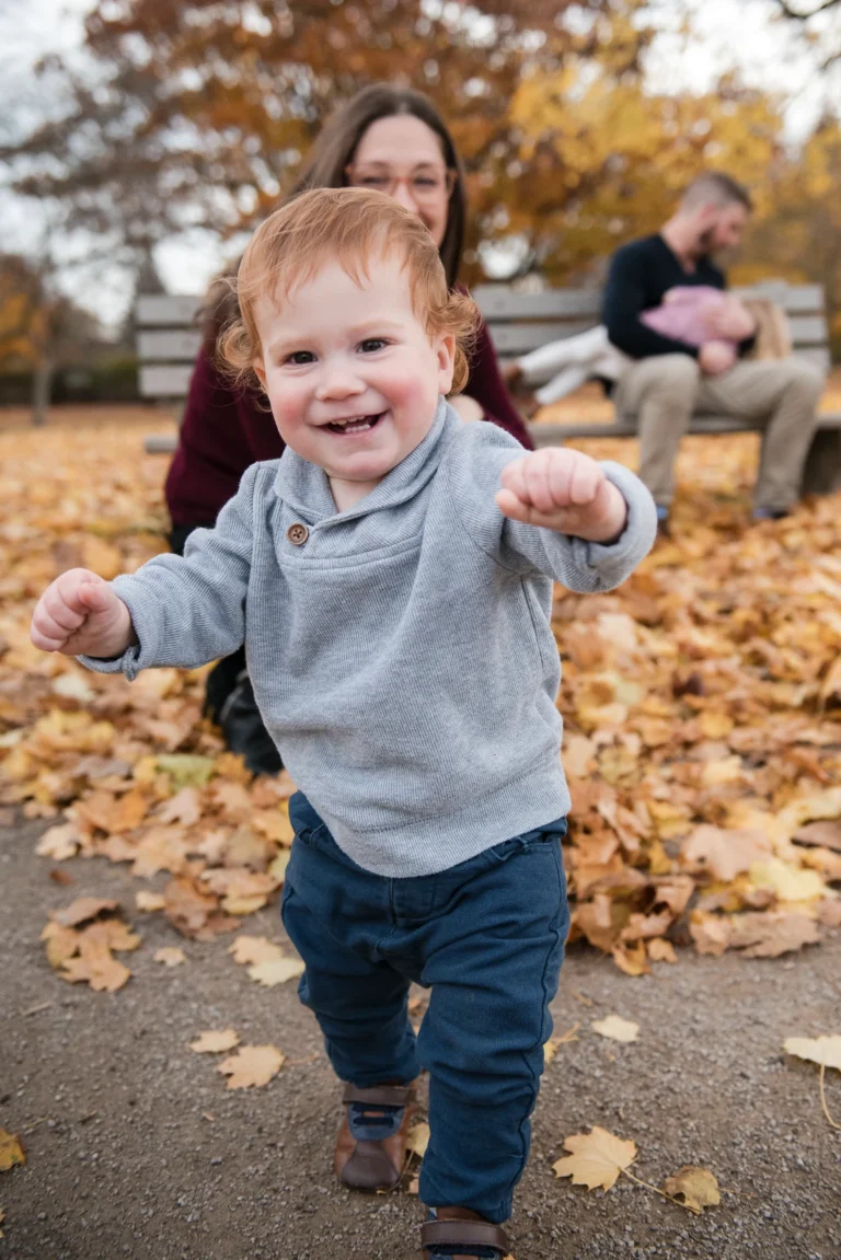 a little boy runs towards the camera as the rest of his family is blurred behind him -shot at dundurn castle in hamilton ontario
