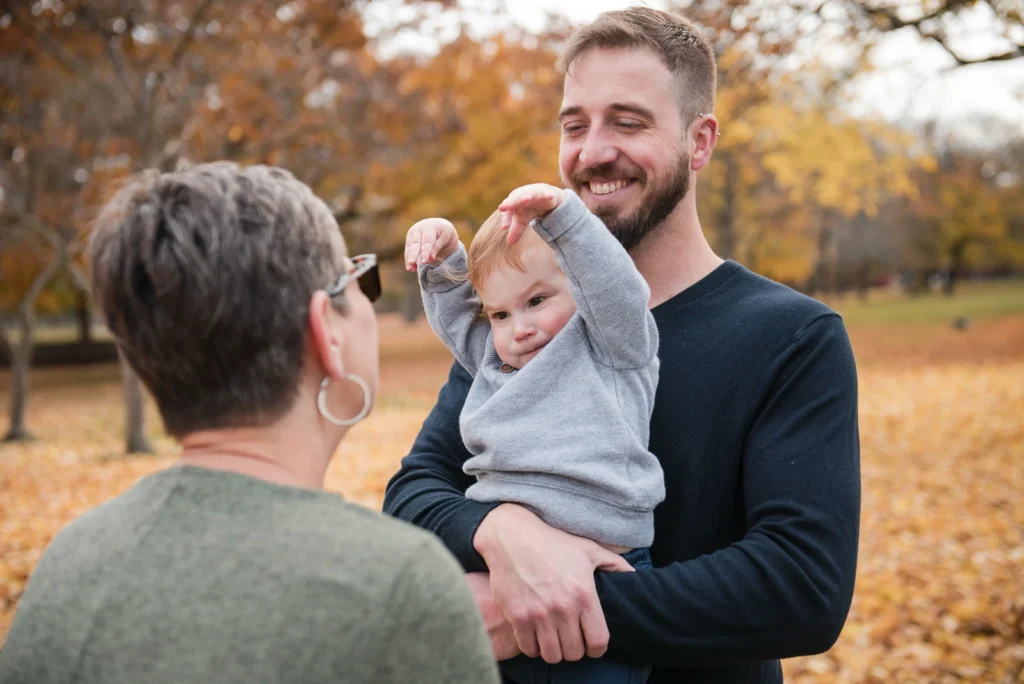 a little boy is held by his father and plays with his grandmother who is standing in front of them - shot at dundurn castle in hamilton ontario