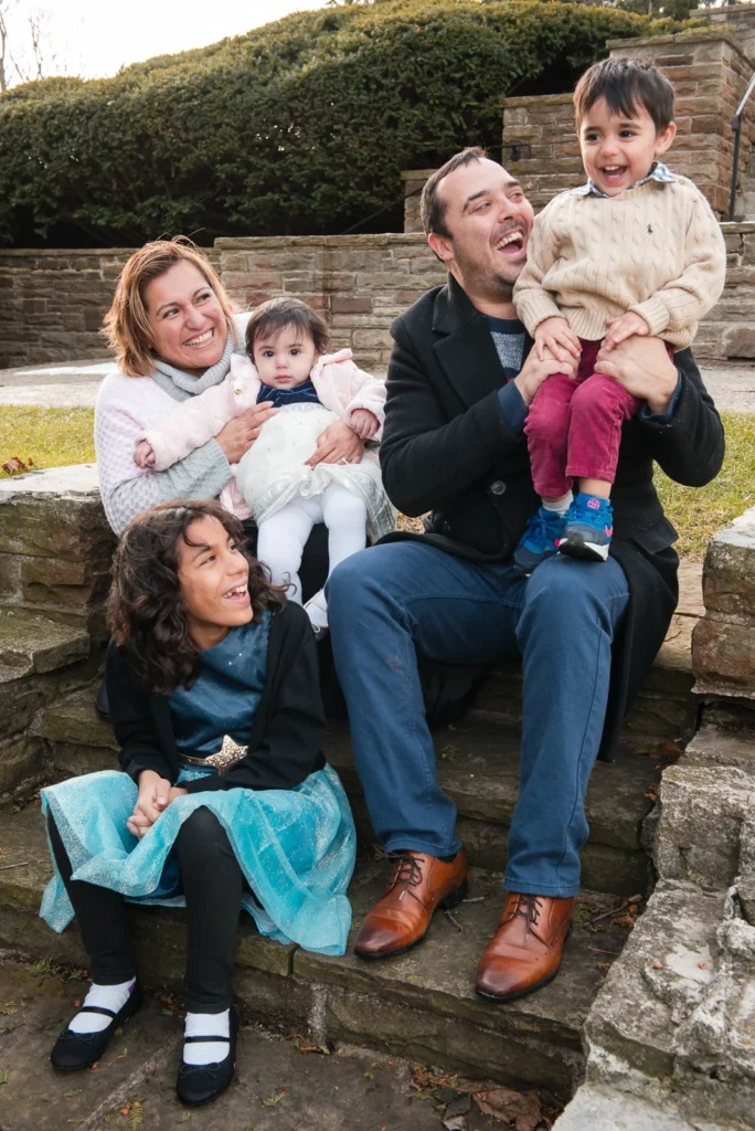 a family of five play on stone stairs - a family portrait shot at Paletta Mansion in Burlington, Ontario