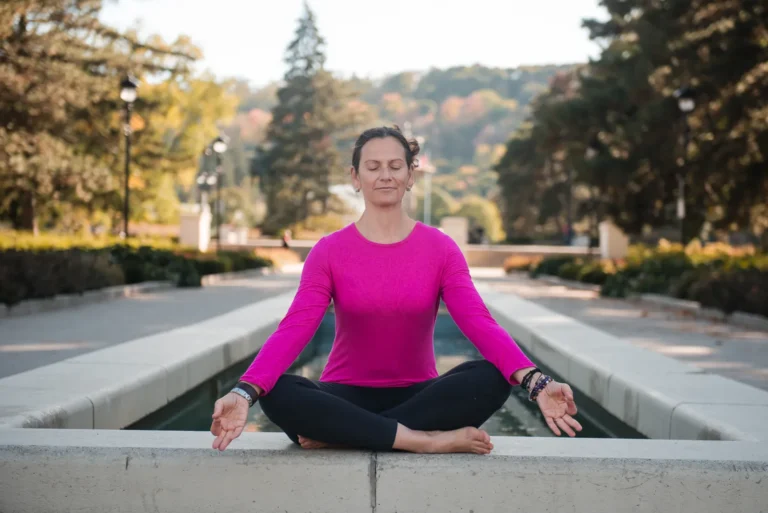 a yoga teacher in lotus position outside- a headshot shot by Hamilton headshot photographer : Pixelesque Photography