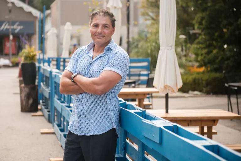 a man stands confidently in front of an empty patio - a headshot shot by Hamilton headshot photographer : Pixelesque Photography