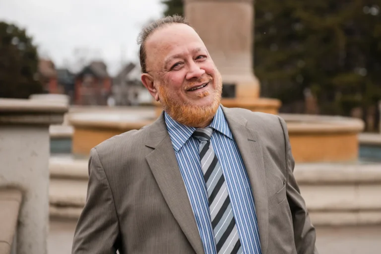 a man in a suit smiles at the camera - a headshot shot by Hamilton headshot photographer : Pixelesque Photography