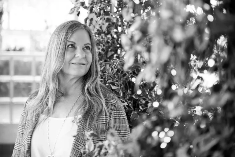 a woman looks at some trees in a greenhouse in black and white - a headshot shot by hamilton headshot photographer : Pixelesque Photography