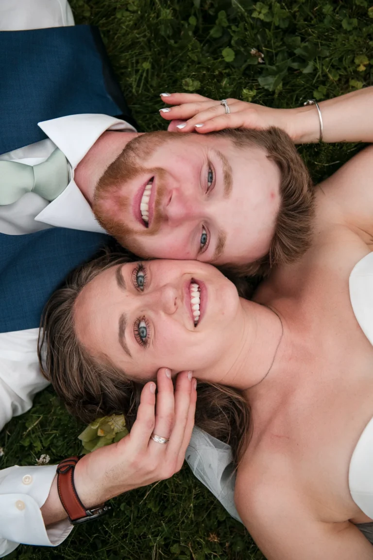 An overhead view of the bride and groom laying beside each other with their cheeks touching. Shot by Pixelesque Photography - Hamilton Wedding Photographer.
