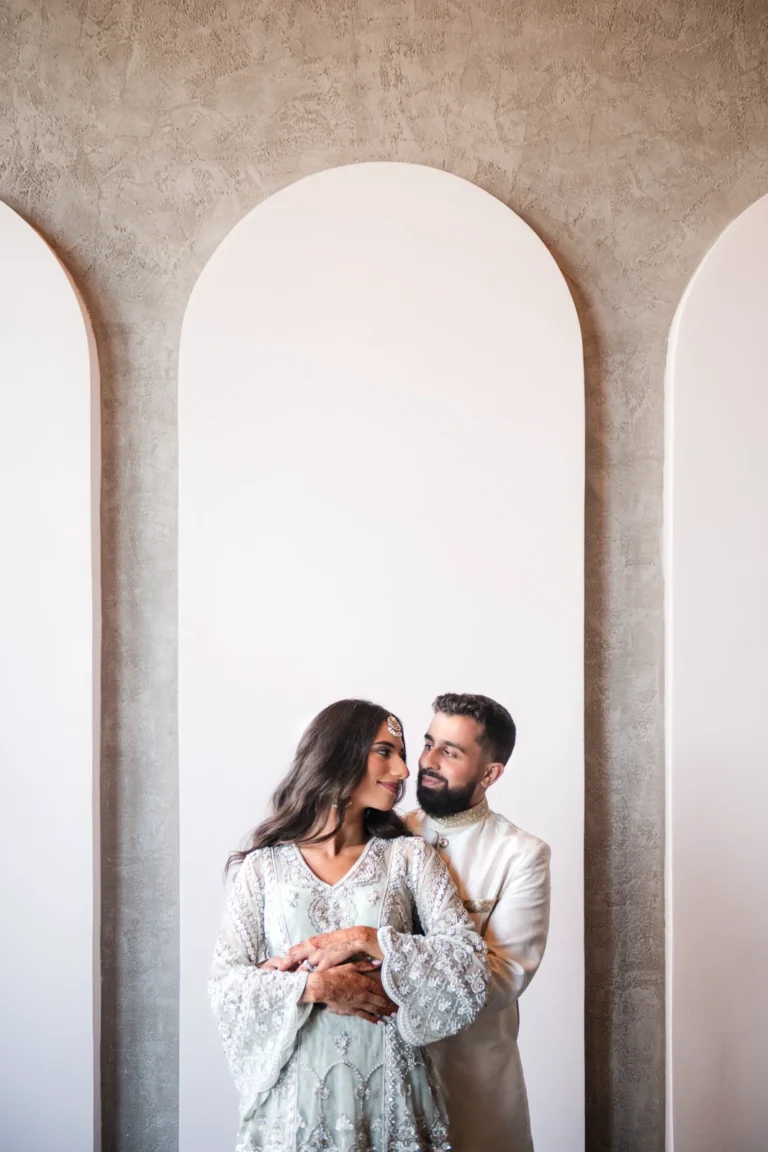 An Indian couple embrace framed by the arches of Mint Room Studios. Shot by Pixelesque Photography - Hamilton Wedding Photographer.