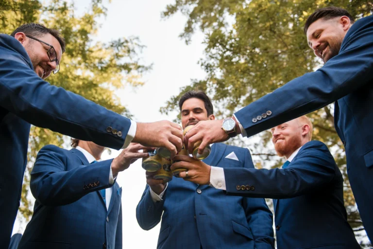 A groom and his groomsmen cheers their beers before the day kicks off. Shot at Dundas Valley Golf and curling club by Pixelesque Photography - Hamilton Wedding Photographer.