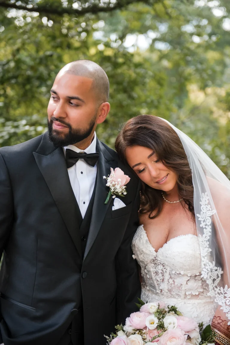 A groom looks off into the distance as his bride lays her head on his shoulder. Shot by Pixelesque Photography - Hamilton Wedding Photographer.
