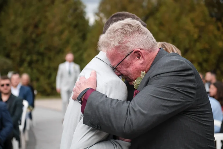A father breaks down in tears as he hugs his son, the groom. Shot by Pixelesque Photography - Hamilton Wedding Photographer.
