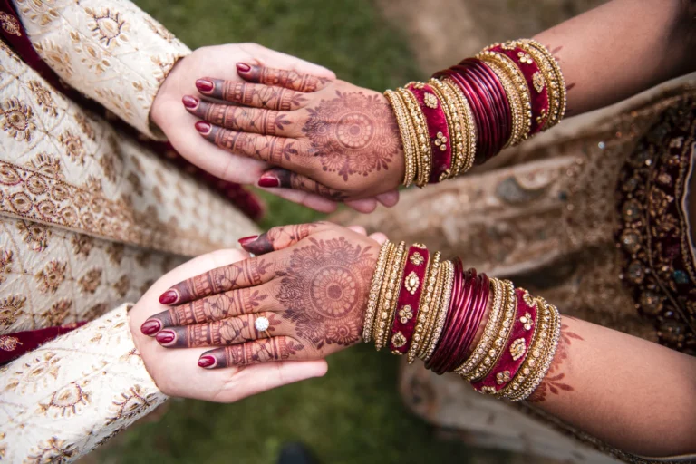 A top down view of a bride's henna covered hands on her grooms, both in traditional indian garb. Shot at Stonewall Estate by Pixelesque Photography - Hamilton Wedding Photographer.