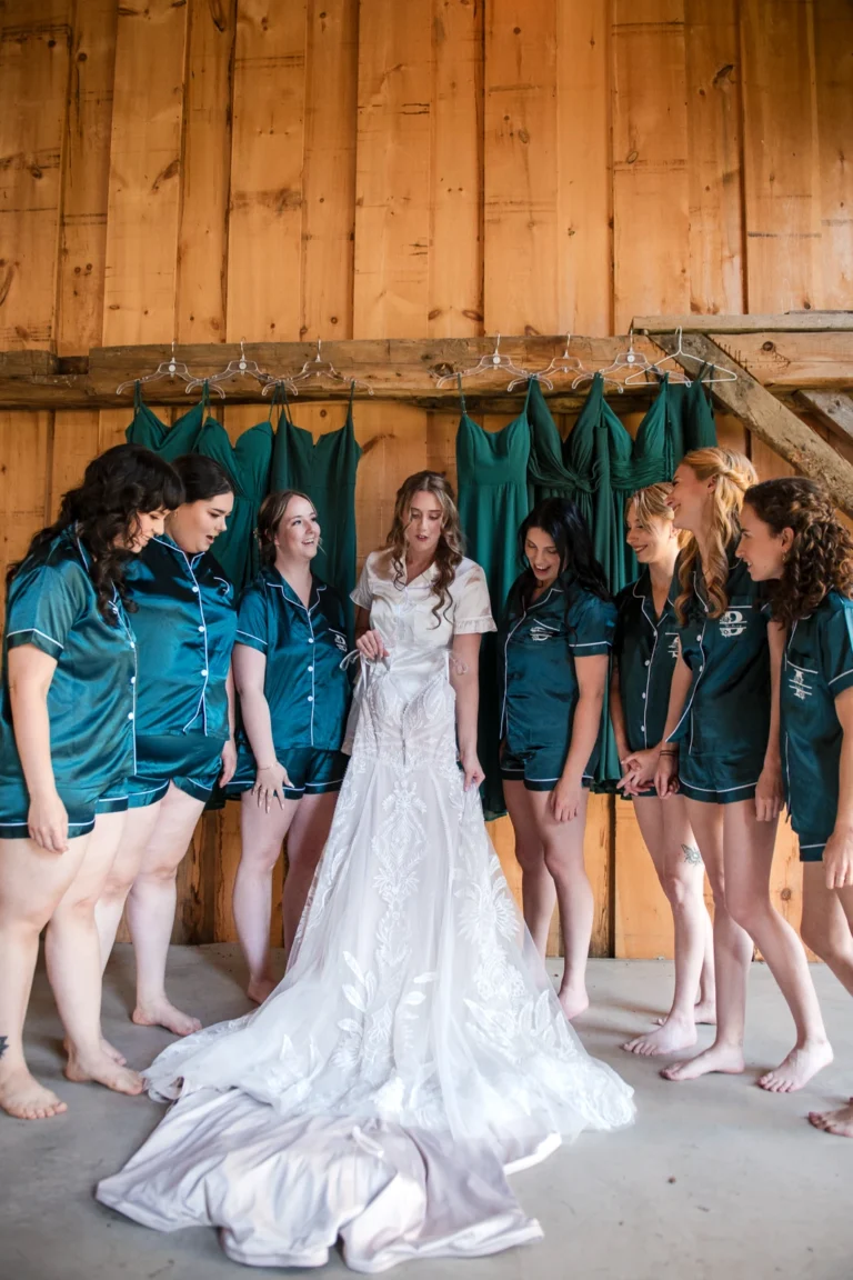 A bride shows off her dress to her bridesmaids. Shot at Homegrown Hideaway by Pixelesque Photography - Hamilton Wedding Photographer.