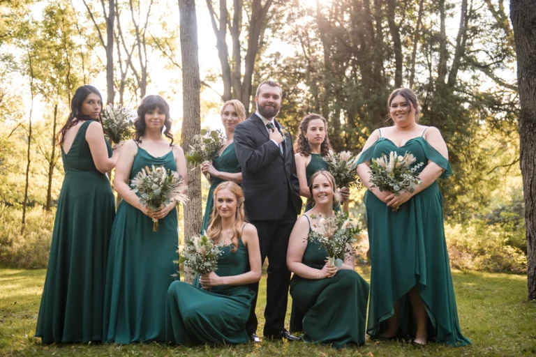 A groom poses with the bridesmaids. Shot at Homegrown Hideaway by Pixelesque Photography - Hamilton Wedding Photographer.
