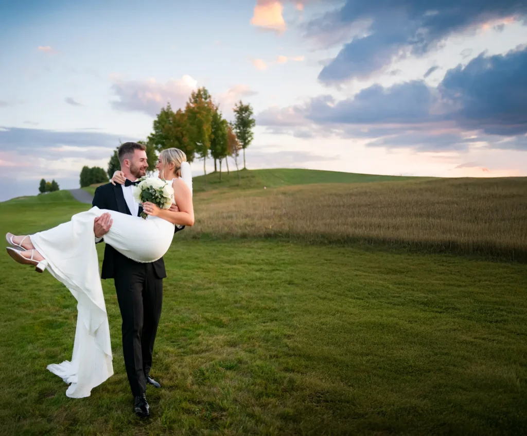 After the Rains : Kayla & Kyle's Whistle Bear Golf Club Wedding 25 the groom carries the bride while they look at each other. Shot at Whistle Bear Golf Club by Pixelesque Photography - Hamilton Wedding Photographer.