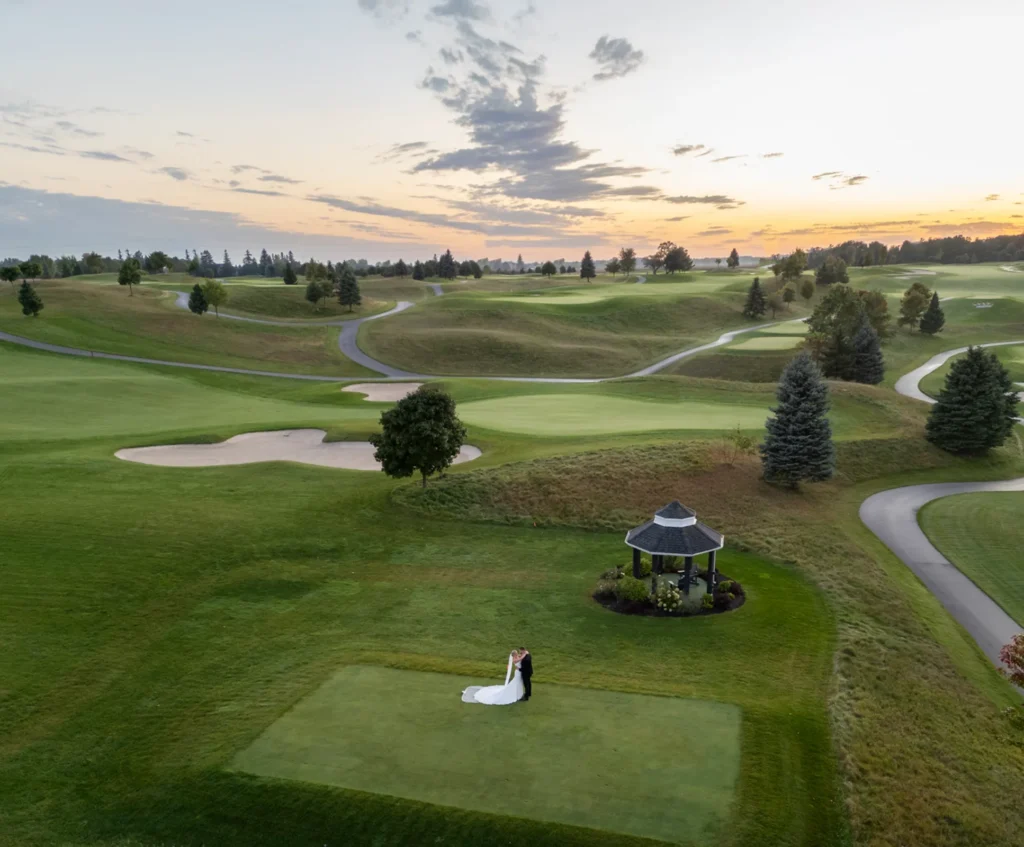 a drone shot of the wedding couple embracing on a golf course. Shot at Whistle Bear Golf Club by Pixelesque Photography - Hamilton Wedding Photographer.