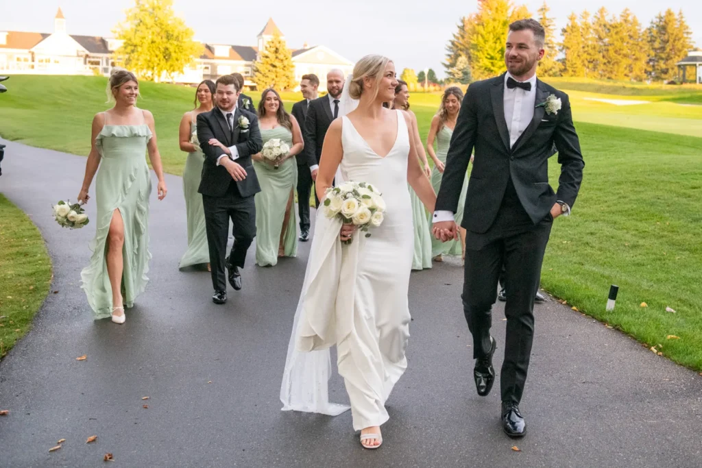 After the Rains : Kayla & Kyle's Whistle Bear Golf Club Wedding 15 bride and groom walk hand in hand with the wedding party behind them. Shot at Whistle Bear Golf Club by Pixelesque Photography - Hamilton Wedding Photographer.