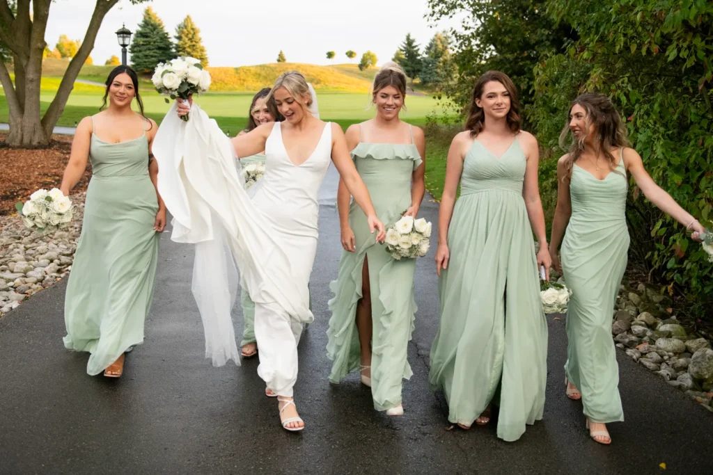 After the Rains : Kayla & Kyle's Whistle Bear Golf Club Wedding 16 the bride tosses her dress in the air as she and her bridesmaids sassily walk down a path. Shot at Whistle Bear Golf Club by Pixelesque Photography - Hamilton Wedding Photographer.