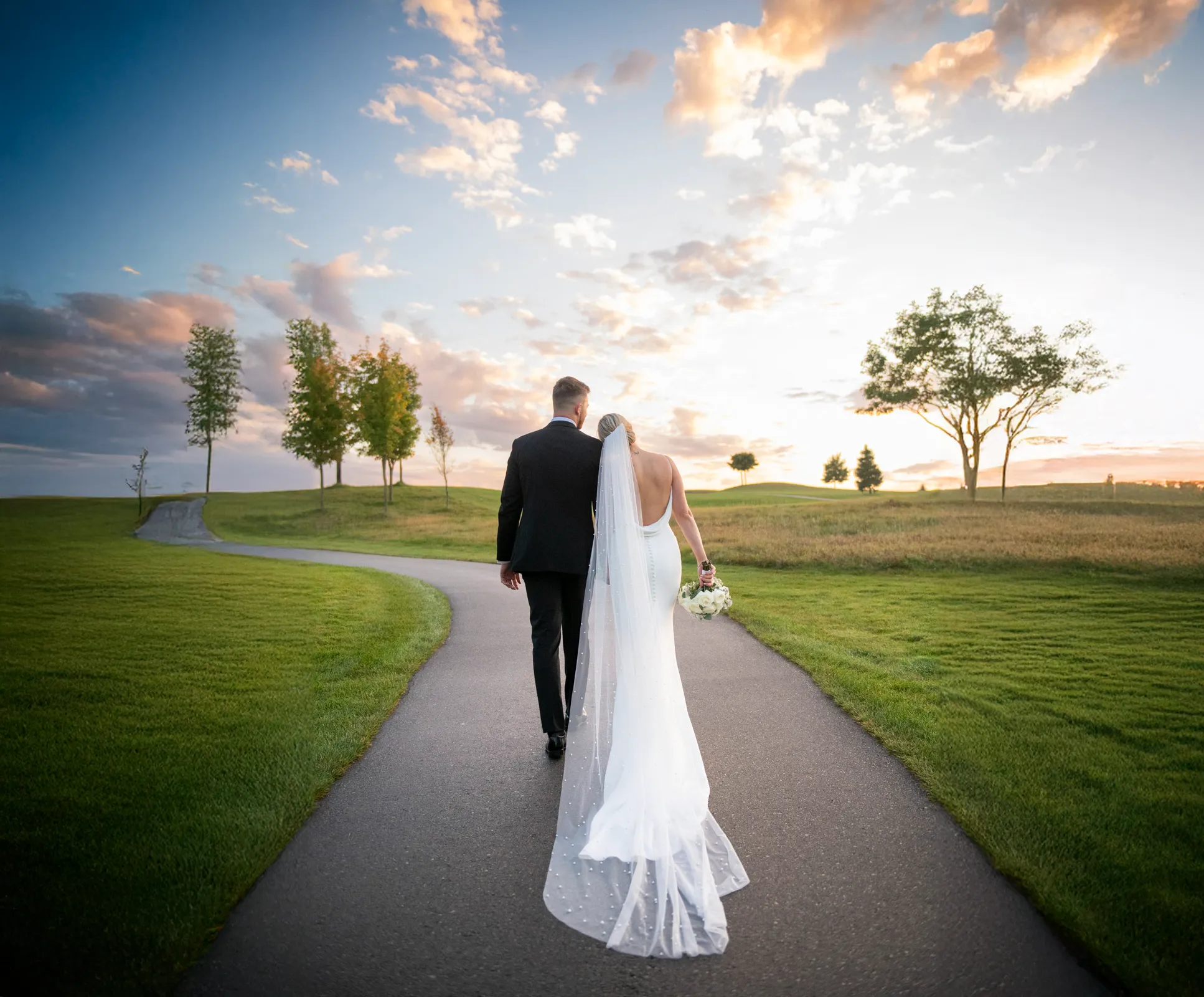 the wedding couple walk down a path away from the camera. Shot at Whistle Bear Golf Club by Pixelesque Photography - Hamilton Wedding Photographer.