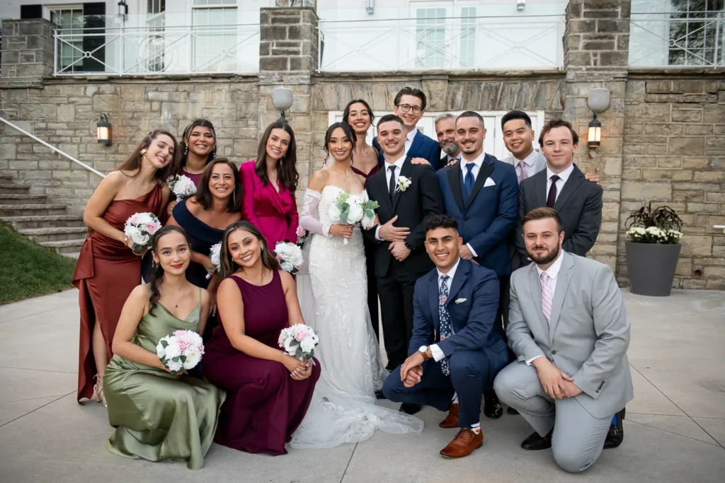 A casual group shot of the bride, groom and their wedding party. One of many beautiful moments from a wedding at Harding Waterfront Estate in Oakville, by Pixelesque Photography - Hamilton Wedding Photographer.