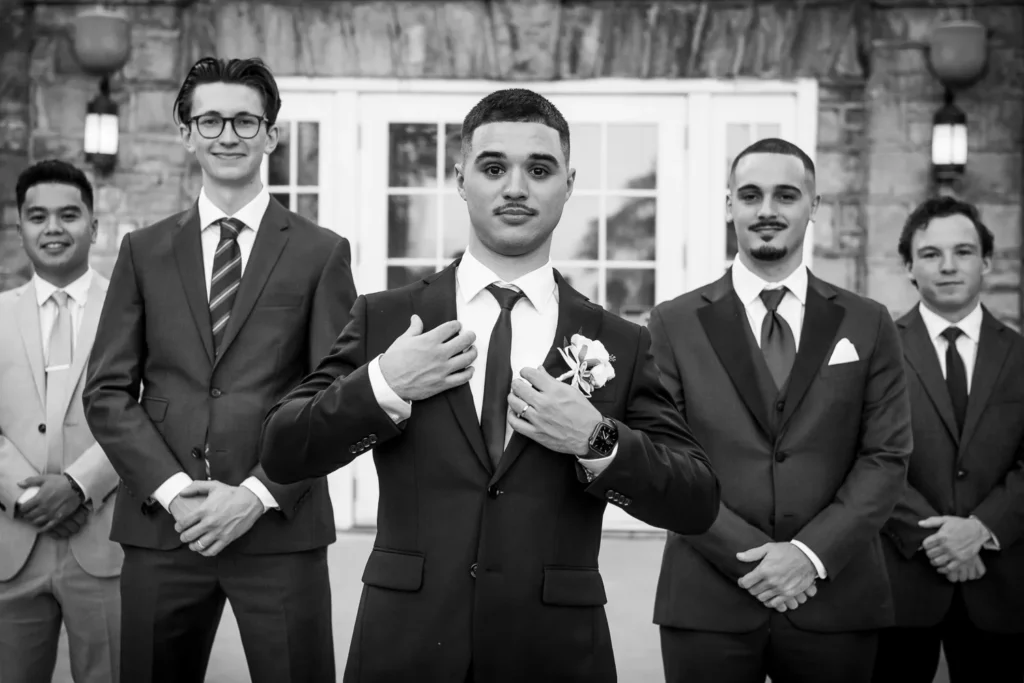 the groom fixes himself up in front of his groomsmen. One of many beautiful moments from a wedding at Harding Waterfront Estate in Oakville, by Pixelesque Photography - Hamilton Wedding Photographer.