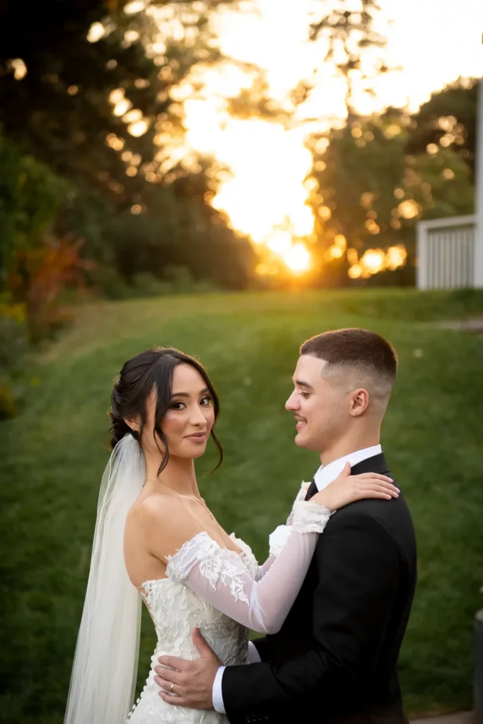 the sun sets behind the couple in embrace. One of many beautiful moments from a wedding at Harding Waterfront Estate in Oakville, by Pixelesque Photography - Hamilton Wedding Photographer.
