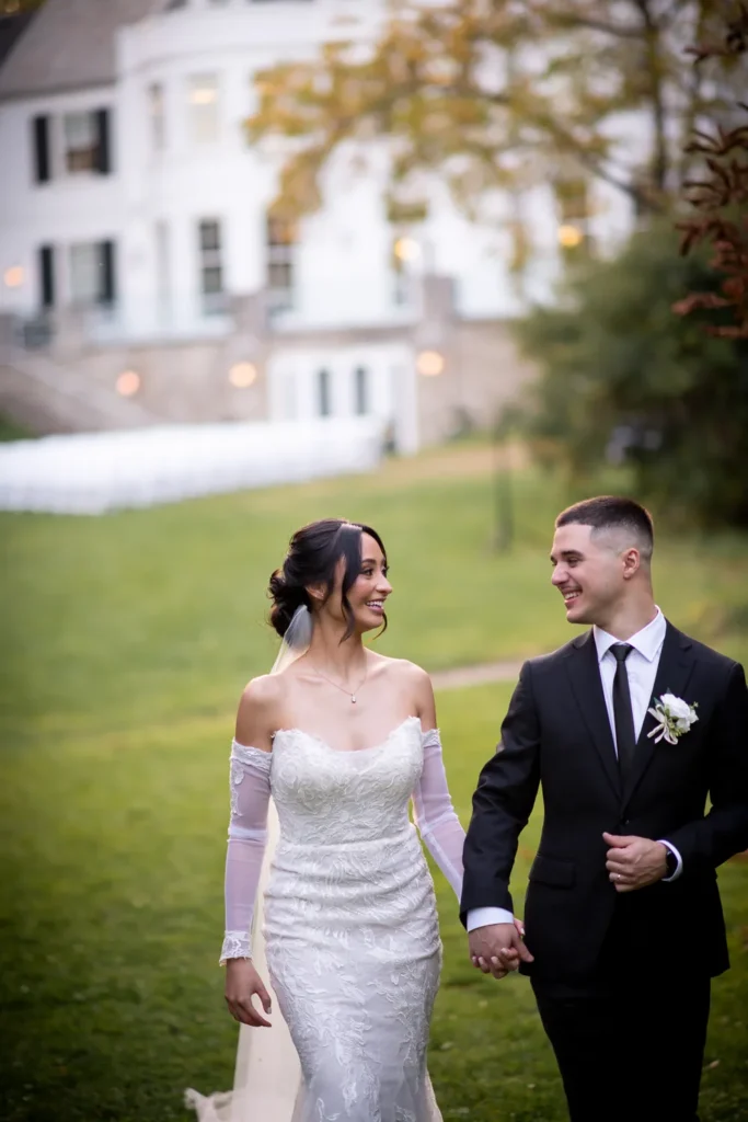 the couple walk away from the venue hand in hand. One of many beautiful moments from a wedding at Harding Waterfront Estate in Oakville, by Pixelesque Photography - Hamilton Wedding Photographer.