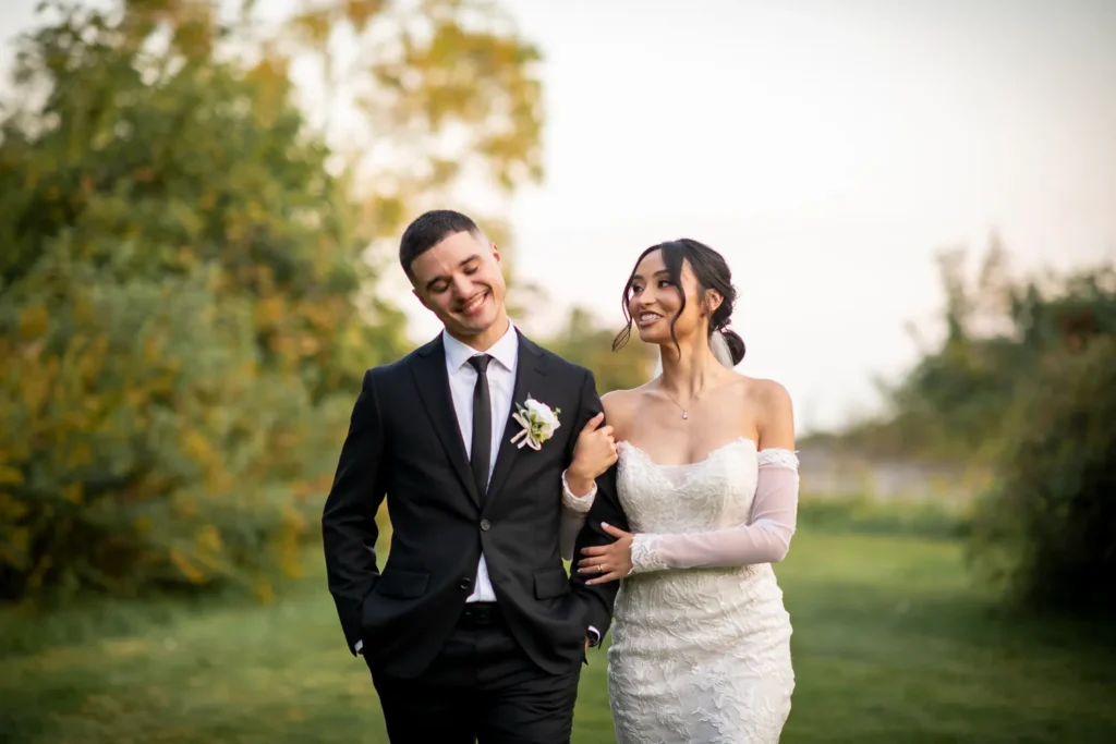 the couple walk arm in arm. One of many beautiful moments from a wedding at Harding Waterfront Estate in Oakville, by Pixelesque Photography - Hamilton Wedding Photographer.