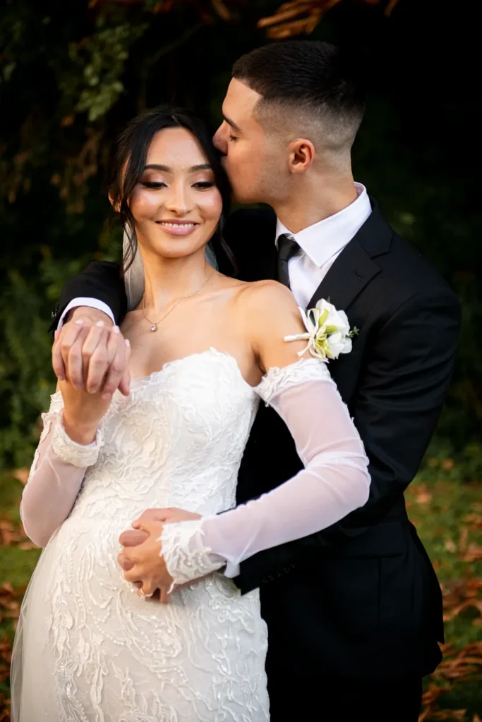 the groom kisses his wife's temples. One of many beautiful moments from a wedding at Harding Waterfront Estate in Oakville, by Pixelesque Photography - Hamilton Wedding Photographer.