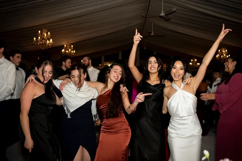 the couple surrounded by friends and family on the dance floor. One of many beautiful moments from a wedding at Harding Waterfront Estate in Oakville, by Pixelesque Photography - Hamilton Wedding Photographer.
