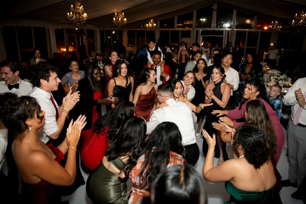the couple surrounded by friends and family on the dance floor. One of many beautiful moments from a wedding at Harding Waterfront Estate in Oakville, by Pixelesque Photography - Hamilton Wedding Photographer.
