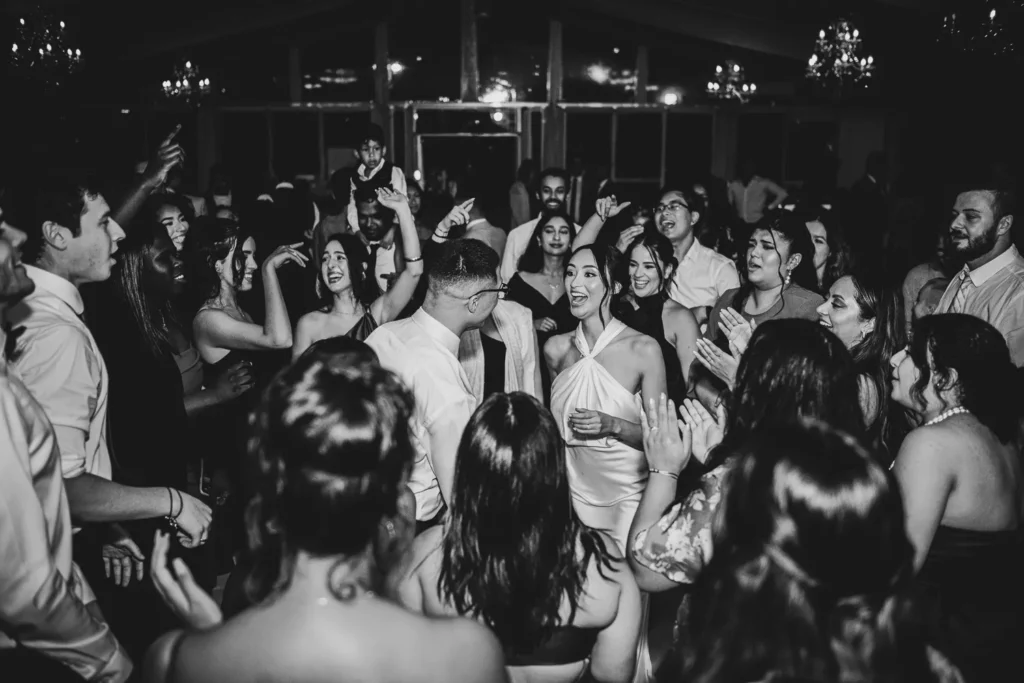 the couple surrounded by friends and family on the dance floor. One of many beautiful moments from a wedding at Harding Waterfront Estate in Oakville, by Pixelesque Photography - Hamilton Wedding Photographer.