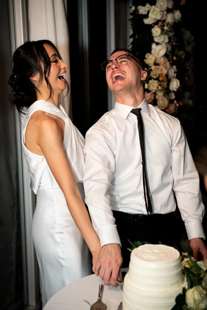 the bride and groom share a laugh as they cut the cake. One of many beautiful moments from a wedding at Harding Waterfront Estate in Oakville, by Pixelesque Photography - Hamilton Wedding Photographer.