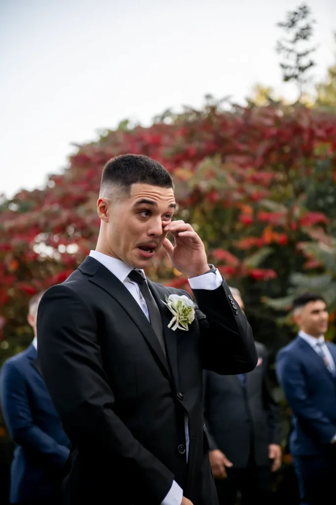 the group wipes a tear as he watches his bride walk down the aisle. One of many beautiful moments from a wedding at Harding Waterfront Estate in Oakville, by Pixelesque Photography - Hamilton Wedding Photographer.