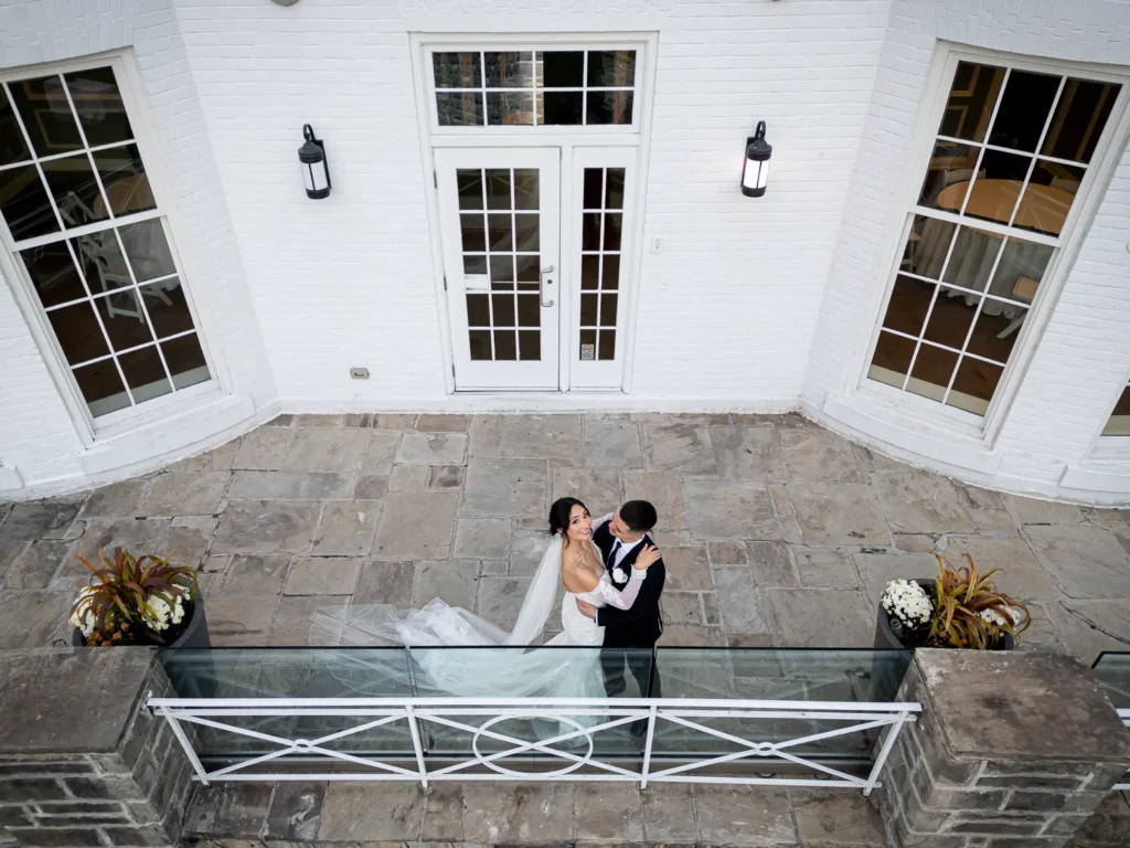a drone shot of the couple on the terrace. One of many beautiful moments from a wedding at Harding Waterfront Estate in Oakville, by Pixelesque Photography - Hamilton Wedding Photographer.