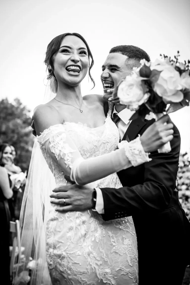 the bride and groom share a fun loving moment at the exit of the aisle. One of many beautiful moments from a wedding at Harding Waterfront Estate in Oakville, by Pixelesque Photography - Hamilton Wedding Photographer.