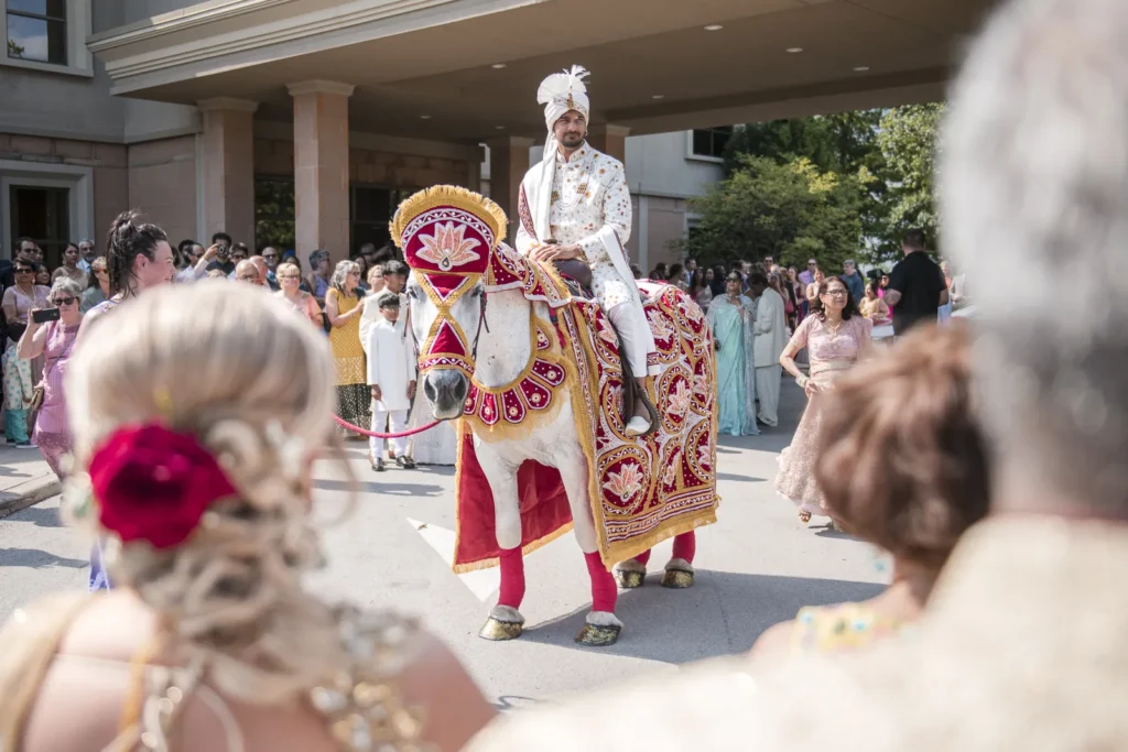 an indian groom on a horse surrounded by guests at winona vine estate - hamilton wedding venue - shot by hamilton wedding photographer- Pixelesque Photography