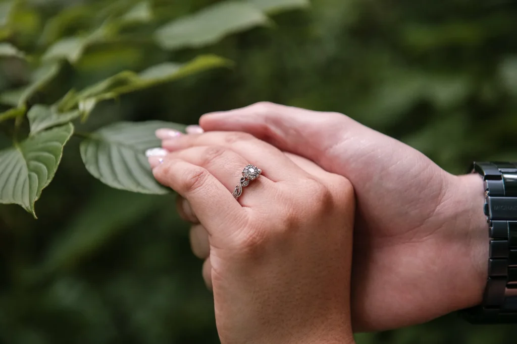 A close up of a man's hand holding a woman's hand with an engagement ring on. Engagement Session Shot at Sherman Falls, Ancaster, by Pixelesque Photography - Hamilton Wedding Photographer.