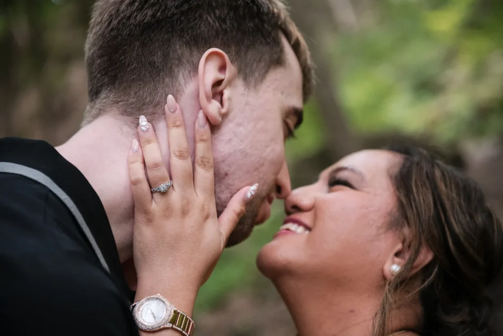 a close up of a couple touching noses in the woods. Engagement Session Shot at Sherman Falls, Ancaster, by Pixelesque Photography - Hamilton Wedding Photographer.