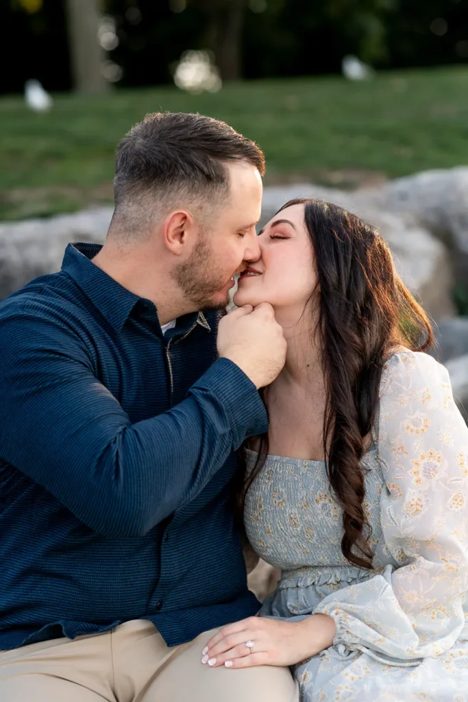 a couple kiss sensually on the rocks of Queen's Royal Park. Part of an engagement shoot Shot in Niagara-on-the-lake by Pixelesque Photography.