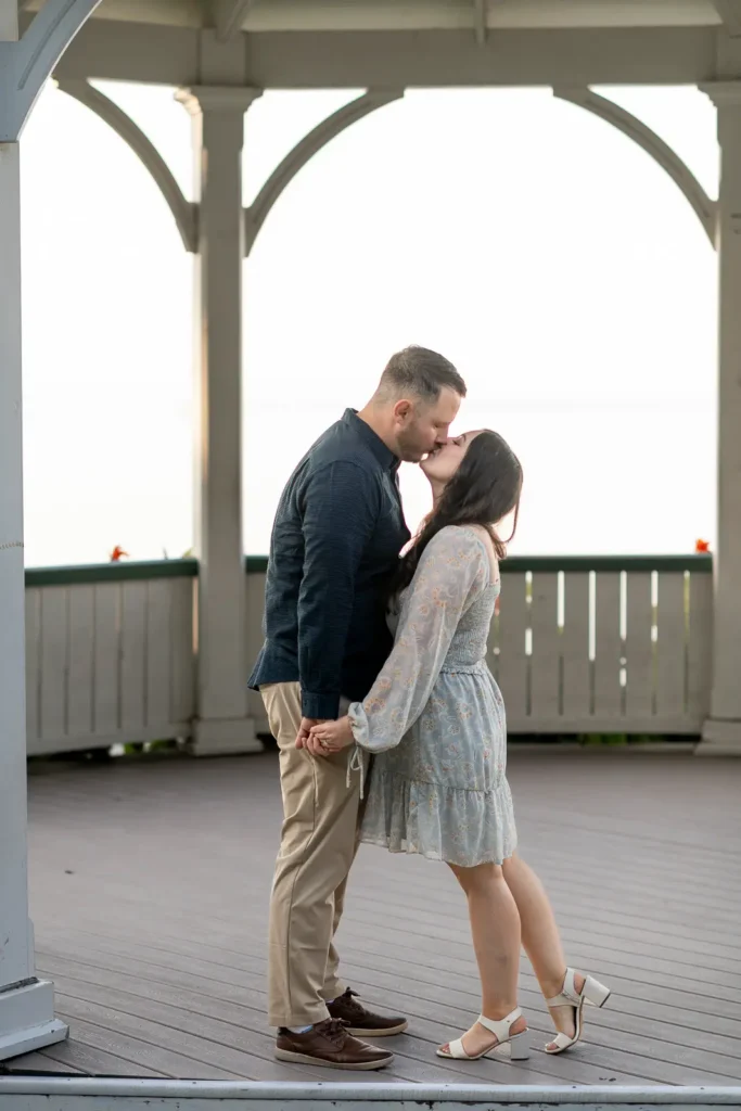 a couple share a gentle kiss inside the iconic queen's royal park gazebo. Part of an engagement shoot Shot in Niagara-on-the-lake by Pixelesque Photography.
