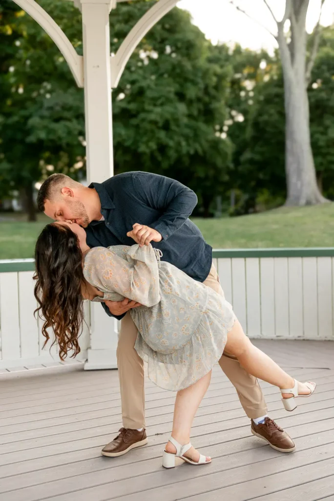 a man dips his partner as they dance in the iconic queen's royal park gazebo. Part of an engagement shoot Shot in Niagara-on-the-lake by Pixelesque Photography.