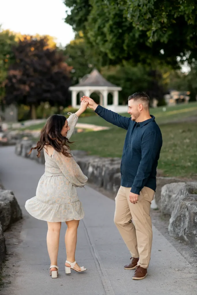 a couple dance along a path with the iconic queen's royal park gazebo in the background.