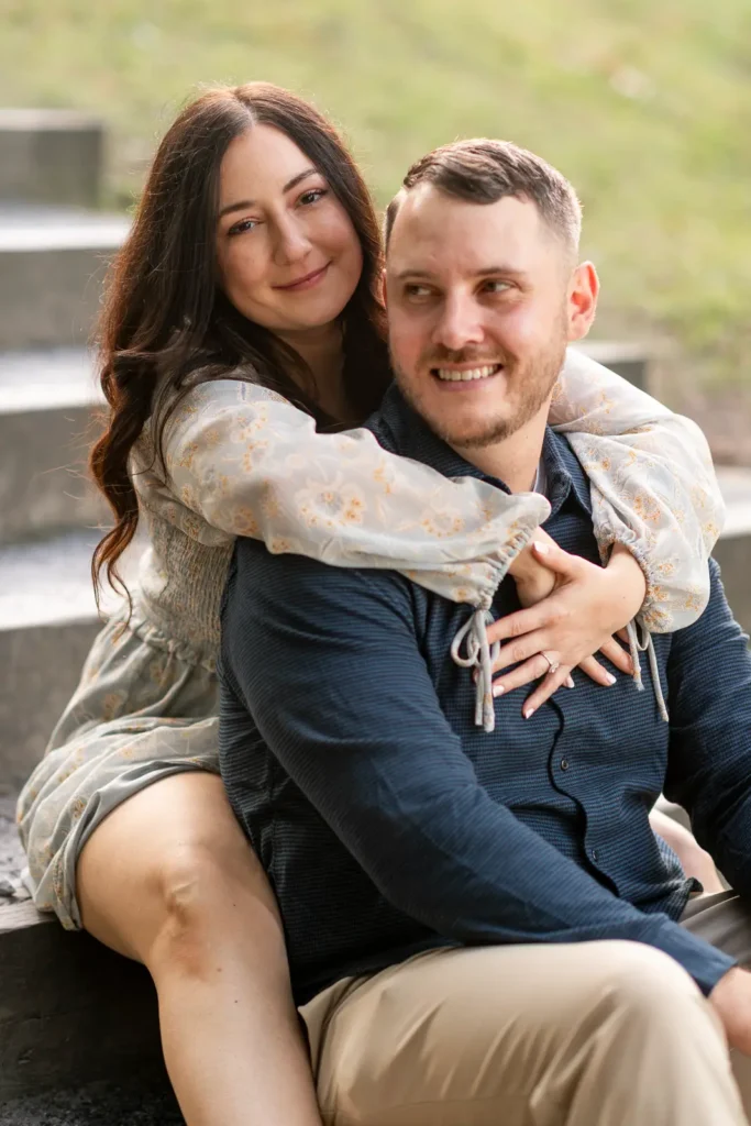 a couple sit on some steps of Queen's Royal Park. Part of an engagement shoot Shot in Niagara-on-the-lake by Pixelesque Photography.