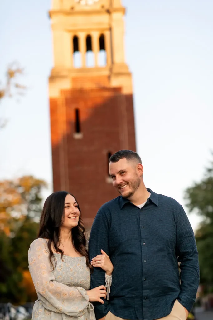 a couple walk arm in arm with the iconic NOTL clock tower behind them. Part of an engagement shoot Shot in Niagara-on-the-lake by Pixelesque Photography.
