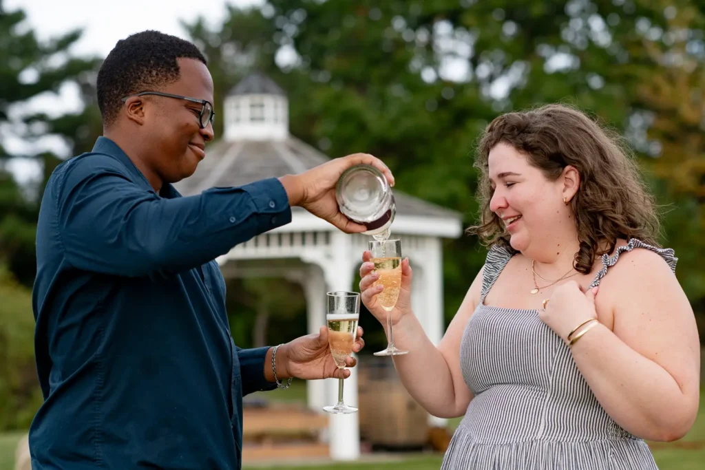 A couple drinking Champagne after a proposal photos at Konzelmann Estate in Niagara-on-the-Lake