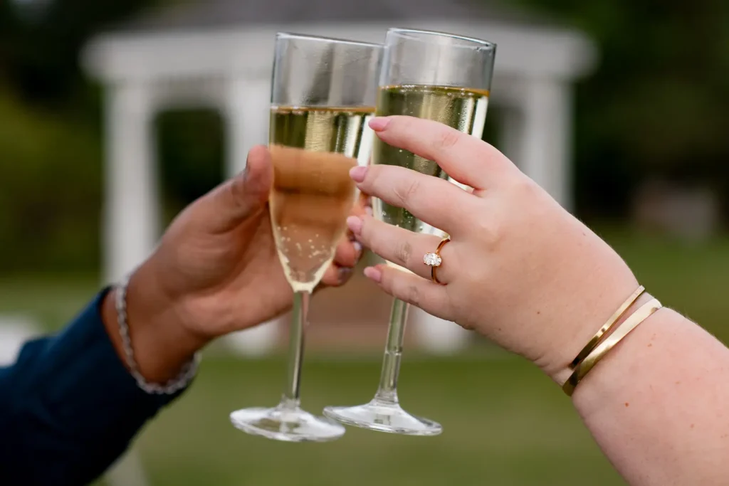 A couple drinking Champagne after a proposal photos at Konzelmann Estate in Niagara-on-the-Lake