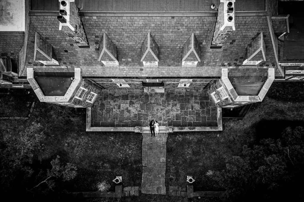 A couple lay together at the front step of Mclean house in North York, Toronto. A wedding day drone photograph shot by Pixelesque Photography - Hamilton wedding Photographer.