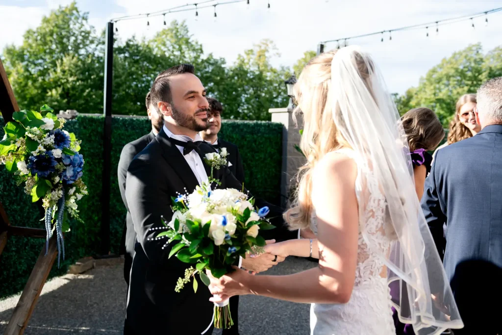 the groom welcomes his bride at the head of the aisle. Shot at Carmen's event centre, Hamilton by Pixelesque Photography.