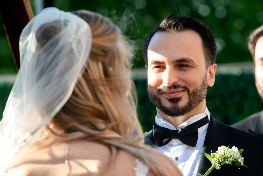 the sun splashes on the groom's face as he looks at his bride.Shot at Carmen's event centre, Hamilton by Pixelesque Photography.